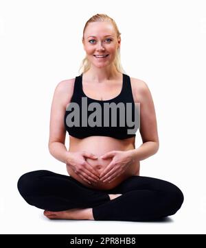 Femme enceinte avec les mains formant le coeur contre le blanc. Amour et nouvelle vie - femme enceinte avec les mains formant le coeur sur fond blanc. Banque D'Images