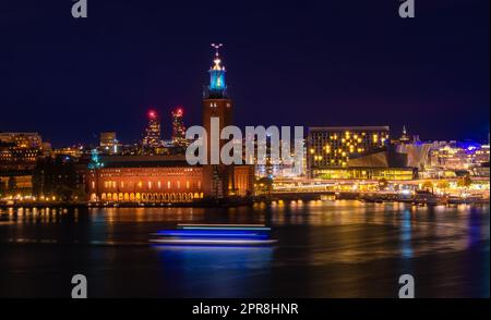 Stockholm, Suède - - 24 septembre 2022 : le majestueux hôtel de ville se dresse contre un horizon de tours illuminées, se reflétant dans l'eau placide en dessous Banque D'Images