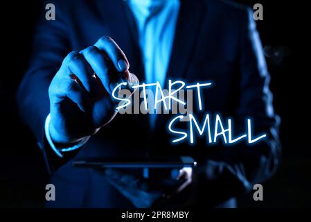 Panneau d'écriture à la main Start Small. Concept signification les petites moyennes entreprises commencent l'esprit d'entreprise main avec Pen pointant des informations importantes avec d'autres tablettes de maintien Banque D'Images