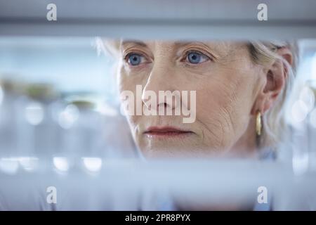 Une femme scientifique mature à la recherche d'un produit dans son laboratoire. Banque D'Images