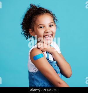 Je suis une grande fille maintenant. Une petite fille montrant un bandaid sur son bras. Banque D'Images