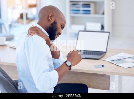 Les tensions s'accentuent : un jeune homme d'affaires souffrant de maux de dos dans un bureau moderne au travail. Banque D'Images