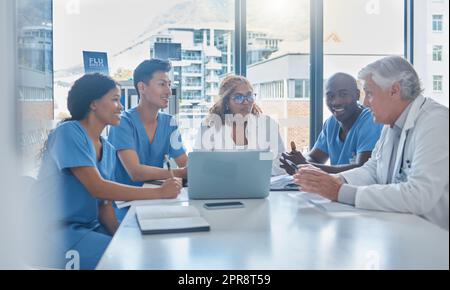 Un groupe de professionnels de la santé assis dans la salle de conférence de l'hôpital pendant une réunion. Banque D'Images