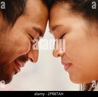 Gros plan d'un homme de race mixte qui aime sa femme asiatique. Photo d'un couple hispanique qui partage un moment intime à la maison. Belle femme avec des taches de rousseur se sentant amoureuse d'un petit ami Banque D'Images