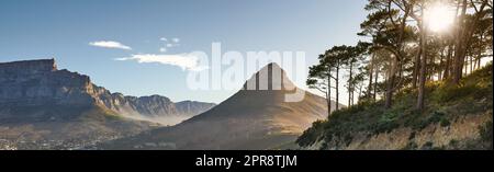 Paysage de montagnes au Cap, Afrique du Sud contre ciel bleu nuageux avec espace de copie. Vue sur les arbres et les arbustes qui poussent sur une colline et une falaise rocheuses dans un environnement naturel proche de Lions Head Banque D'Images