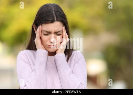 L'adolescence a stressé souffrant de migraine dans un parc Banque D'Images