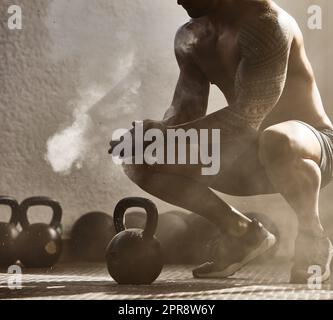 Fitness, entraînement d'un homme de bien-être sain dans une salle de gym. Grand mâle musclé se préparer pour le levage de poids, se préparer en claquant les mains avec de la poussière de poudre. Tenue, forte et athlétique culturiste carrossier d'entraînement de type. Banque D'Images