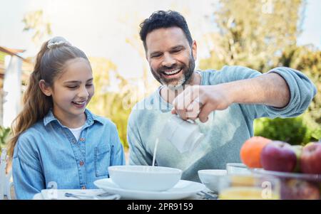 La famille, c'est comme si vous vous ennuyez. C'est une famille heureuse qui prend le petit déjeuner ensemble dans le jardin. Banque D'Images