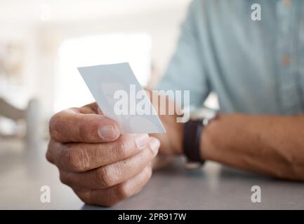 Les souvenirs ne meurent jamais. Une personne méconnaissable tenant une photo à la maison. Banque D'Images