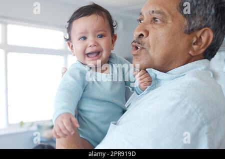 Hé enfant, je vous paie à Taisez-vous. un homme mûr tenant son petit-enfant pleurant à la maison. Banque D'Images