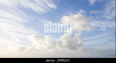 Ciel bleu ciel nuageux avec des nuages moelleux comme un fond naturel lors d'une journée d'été. Vue en paysage du cumulus formant avec l'espace de copie. Vues panoramiques et copyspace sur l'atmosphère et le climat Banque D'Images