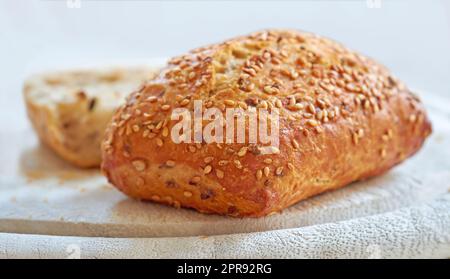 Nourriture. Un pain frais maison de blé entier ou de blé entier, pain de graines de sésame sur une planche, prêt à être coupé. Pour un régime et un mode de vie sains, mangez des aliments riches en fibres. Banque D'Images