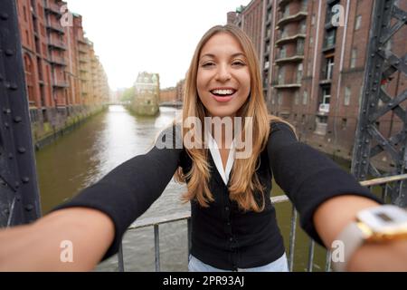 Jeune fille se faisant autoportrait dans le quartier de Speicherstadt, dans le port de Hambourg, en Allemagne Banque D'Images