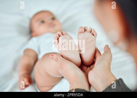 Ces petits pieds occupent le plus d'espace dans mon cœur. Gros plan d'une femme tenant ses petits pieds de babayes. Banque D'Images