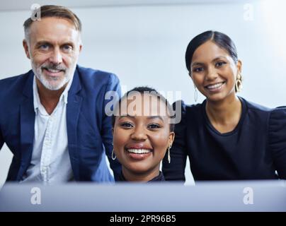 Nous excelons toujours dans ce que nous faisons. Portrait d'un groupe d'hommes d'affaires travaillant ensemble sur un ordinateur portable dans un bureau. Banque D'Images