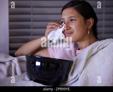 Ce film est vraiment triste. Une jeune femme pleure en regardant la télévision à la maison. Banque D'Images