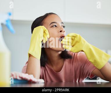 J'ai besoin de faire une sieste. Une jeune femme prenant une forme de pause nettoyant sa cuisine pour frayer. Banque D'Images