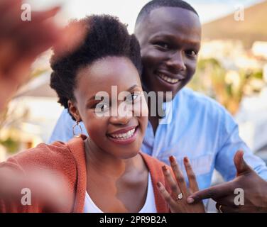 J'ai dit oui à l'homme de mes rêves. Un jeune couple debout ensemble et prenant un selfie tout en célébrant leur engagement. Banque D'Images