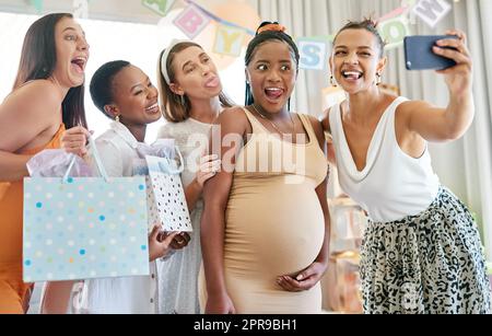 Je ne me souviens pas de ce jour pour toujours. Un groupe d'amis féminins prenant des selfies à une douche de bébé. Banque D'Images