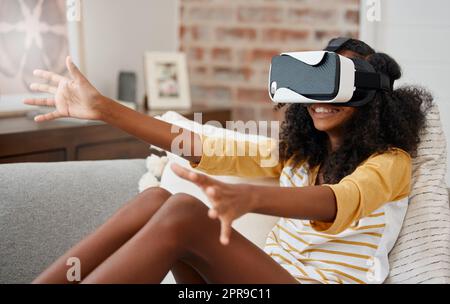 Qui a besoin d'amis. Une jeune fille jouant avec un casque vr à la maison. Banque D'Images