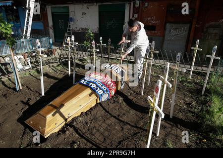 Naples, Italie. 26th avril 2023. Une plante de soutien croise avec les symboles de toutes les équipes italiennes Serie A football à côté d'une tombe factice pour un cercueil orné des foulards des équipes de football FC Inter, FC Juventus et AC Milan devant un club de fans de SSC Napoli. Alors que Napoli pourrait gagner la série Un championnat de football dès le dimanche prochain, les préparatifs pour les célébrations sont en plein essor dans la ville. Crédit : Agence photo indépendante/Alamy Live News Banque D'Images