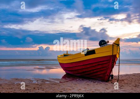 Coucher de soleil sur la mer Baltique avec bateau de pêche sur la plage - Debki, Pomerania, Pologne Banque D'Images