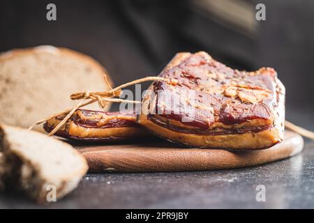Bacon fumé entier sur la planche à découper. Banque D'Images