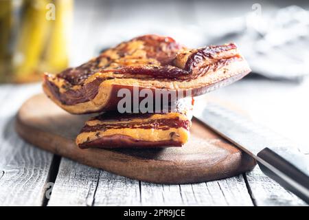 Bacon fumé entier sur la planche à découper. Banque D'Images