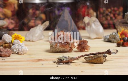 Autel de méditation avec cristaux de roche et fleurs. Pots d'herbes en arrière-plan Banque D'Images