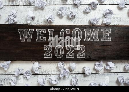 Légende du texte de bienvenue 2022. Photo conceptuelle célébration de la nouvelle année motivation pour commencer les Cheers Félicitations idées importantes écrites sur morceau de bois avec papier enveloppé sur le plancher. Banque D'Images