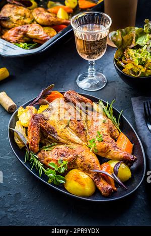 Poulet entier cuit avec des pommes de terre, des carottes et des herbes Banque D'Images