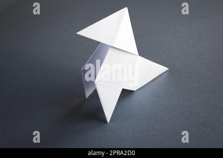 Poule de papier blanc origami isolé sur fond gris Banque D'Images