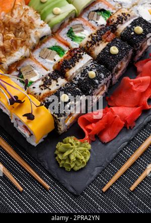 Sushis japonais. Des petits pains Maki et du thon, du saumon, des crevettes, du crabe et de l'avocat. Vue de dessus de l'assortiment de sushis. Banque D'Images