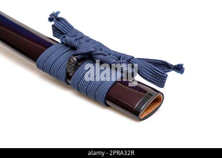 Bleu marine Sageo : corde de soie bleu marine pour le nouage. Barde japonais cramoisi brillant isolé sur fond blanc. Mise au point sélective. Banque D'Images