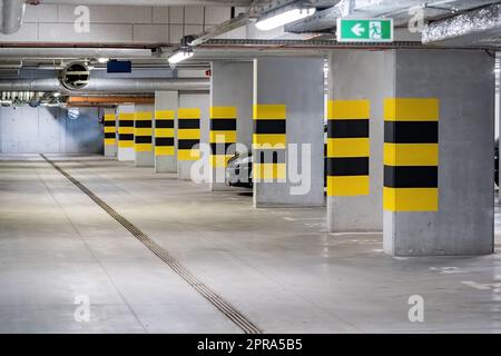 Parking souterrain vide sous un complexe d'appartements moderne, une voiture générique garée, personne, pas de personnes, beaucoup de place de parking gratuit New Real es Banque D'Images