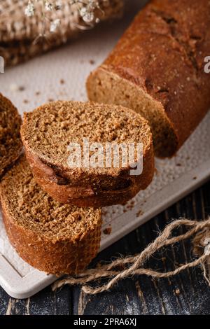 Tranches de pain brun traditionnel fraîchement cuit avec croûte croustillante. Banque D'Images