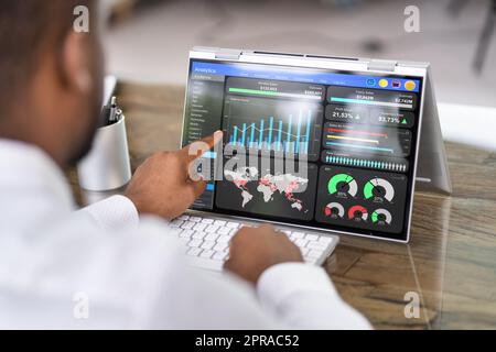 Homme d'affaires africain utilisant le tableau de bord KPI des données analytiques Banque D'Images