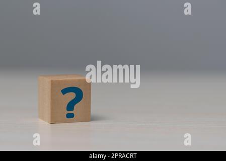 Bloc cube en bois avec symbole de point d'interrogation sur la table. Banque D'Images