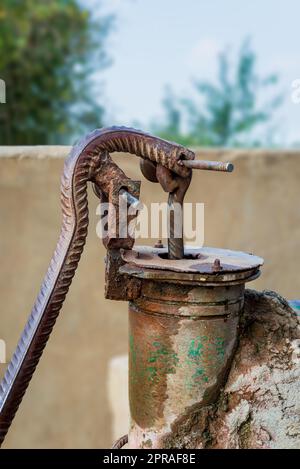 Vieille pompe à eau traditionnelle rouillée à fonctionnement manuel dans le village rural égyptien Banque D'Images