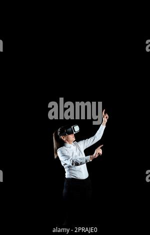 Femme d'affaires qui porte un casque de réalité virtuelle et qui fait des gestes tout en suivant une formation professionnelle. Femme portant un simulateur futuriste et présentant la technologie moderne. Banque D'Images