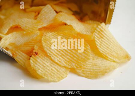 Croustilles dans un sac ouvert, délicieux assaisonnement barbecue épicé pour les pleurs, fine tranche de collation frite rapide. Banque D'Images