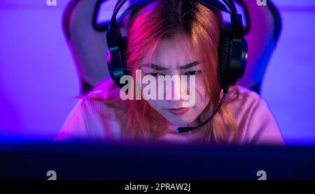 Une jeune femme portant un casque de jeu a l'intention de jouer à des jeux en direct en streaming en ligne Banque D'Images