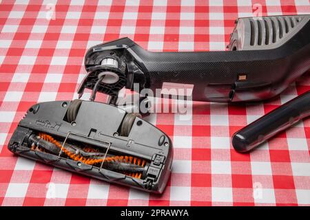 Réparation d'appareils ménagers. Un technicien professionnel répare un aspirateur. Service à la clientèle des appareils ménagers. Batterie hoover. Réparation par un spécialiste sur site. Banque D'Images