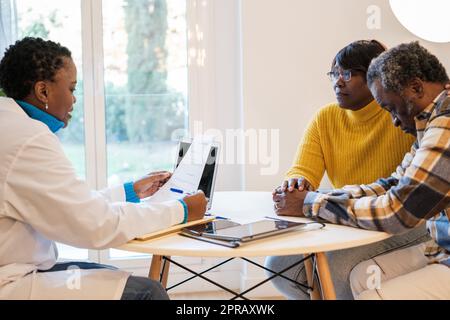 Le jeune médecin donne les résultats des tests médicaux au patient et à son partenaire et ils ont un visage triste. Concept: Soins de santé, maladie, médecine Banque D'Images
