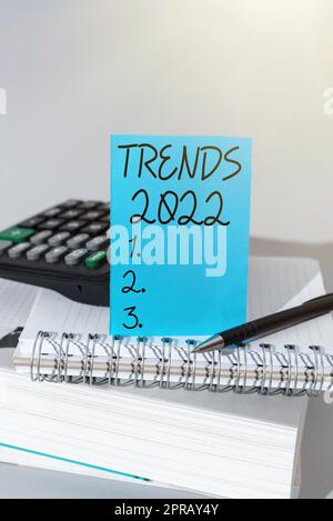 Tendances de l'écriture manuscrite 2022. Photo conceptuelle l'année à venir tendance dominante largement discuté en ligne message important présenté sur morceau de papier sur le bureau avec clavier. Banque D'Images