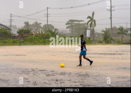 Un jeune joueur de football afro-colombien participe à une session d'entraînement lors d'une tempête tropicale à Quibdó, Chocó, Colombie. Banque D'Images