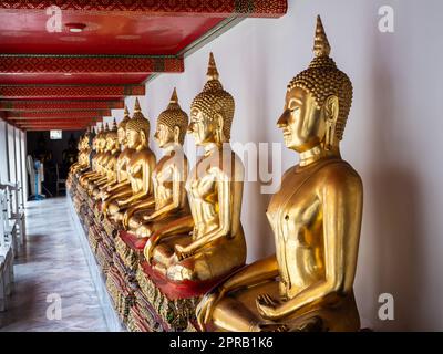 Une vue imprenable sur une longue ligne de statues de Bouddha doré ornant le mur du temple Wat Pho à Bangkok, en Thaïlande. Banque D'Images