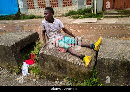 Un jeune joueur de football afro-colombien prend une pause lors d'une séance d'entraînement sur un terrain de jeu de terre à Quibdó, Chocó, Colombie. Banque D'Images