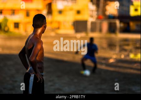 Un jeune joueur de football afro-colombien pratique le contrôle du ballon lors d'une séance d'entraînement sur un terrain de jeu de terre à Quibdó, Chocó, Colombie. Banque D'Images