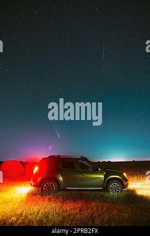 Comet Neowise C/2020 F3 in Night Starry Sky above car SUV en paysage agricole d'été Banque D'Images